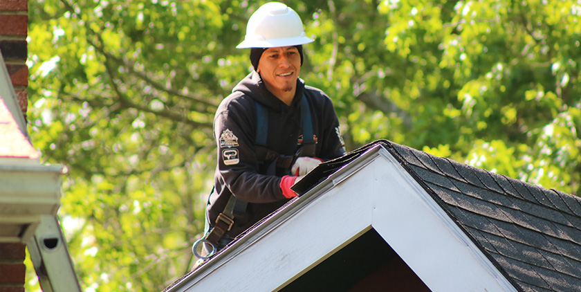 Roof inspector checking residential roof for damage in Massachusetts