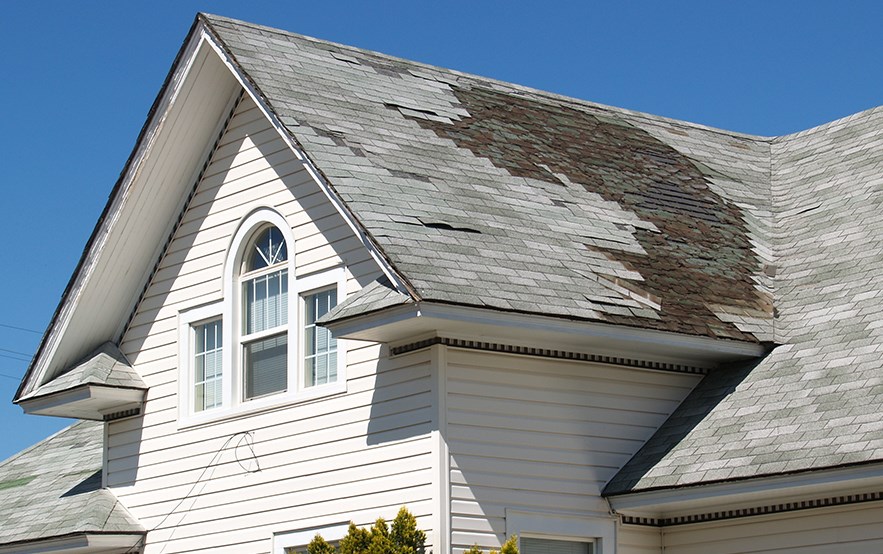 Roof with missing shingles from storm in Massachusetts